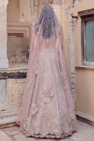 Back view of skin rose lehenga under the long sheer veil showing large flower motifs by Osaa by Adarsh at Mrs. G