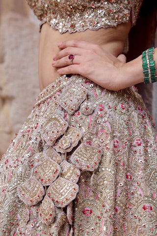 Close-up of cascading petal appliqué and arch embroidery on the skin rose lehenga hip by Osaa by Adarsh at Mrs. G
