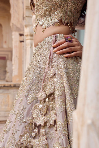 Side close-up of tan lehenga waist with flower tassel tie and zardozi embroidery by Osaa by Adarsh at Mrs. G