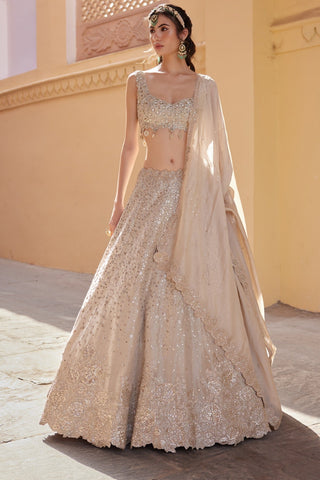 Front view of beige champagne lehenga set with matching dupatta draped over the arm by Osaa by Adarsh at Mrs. G