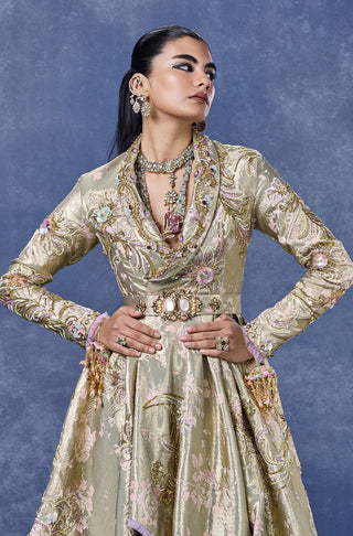 Three-quarter view of the sage gold jacquard gown with a front slit at Mrs. G