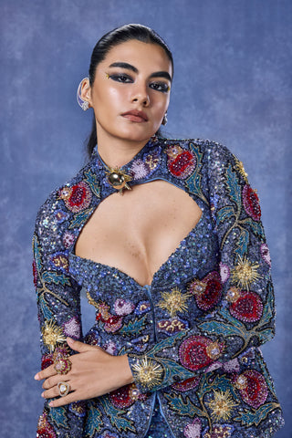 Zoomed-in keyhole neckline and pomegranate embroidery on the blue jacket at Mrs. G