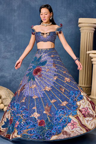 Front view of the blue lehenga in a full twirl with a floral cream and burgundy hem at Mrs. G