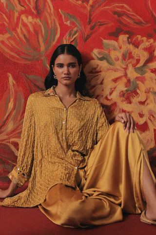 Seated view of the bandhani tunic and dhoti against a floral backdrop, yellow ziya a-line hi-low co-ord set by Twenty Nine at Mrs. G