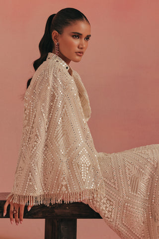 Seated view of the jacket and sharara with a tassel hem, ivory ziya mirrorwork sharara set by Twenty Nine at Mrs. G