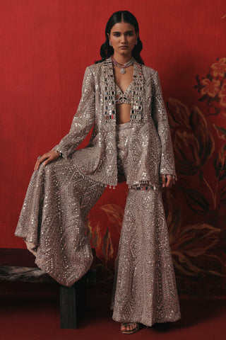 Full-length view with one leg raised on the bench showing the sharara flare, pearl silver ziya jacket sharara set by Twenty Nine at Mrs. G