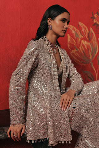 Waist-up view seated in the jacket with mirror work lapels, pearl silver ziya jacket sharara set by Twenty Nine at Mrs. G
